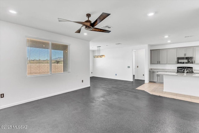 unfurnished living room with ceiling fan and sink