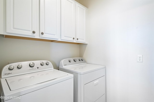 laundry area with washer and clothes dryer and cabinets