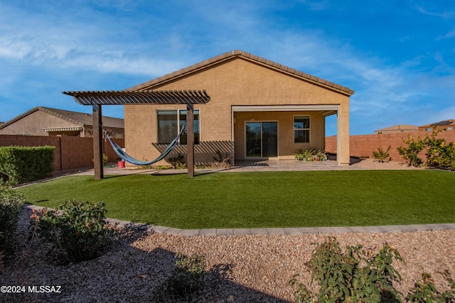 rear view of property featuring a lawn and a patio