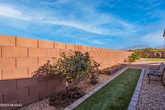 view of yard with a fenced backyard and a mountain view