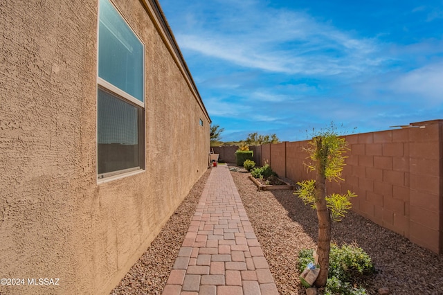 view of side of property featuring a fenced backyard and stucco siding