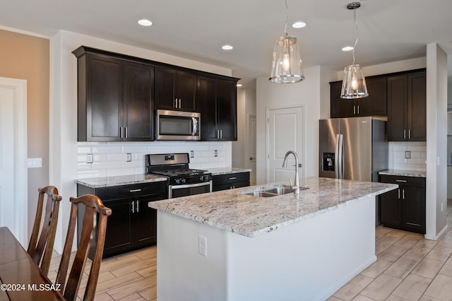 kitchen featuring decorative backsplash, stainless steel appliances, a kitchen island with sink, and sink