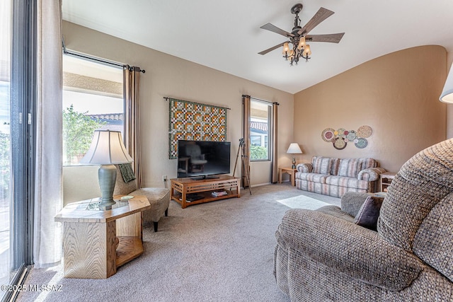 carpeted living room with ceiling fan and vaulted ceiling