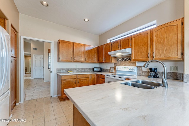 kitchen featuring kitchen peninsula, sink, light tile patterned flooring, and white appliances