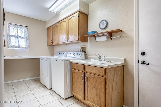 laundry area featuring cabinets, light tile patterned floors, separate washer and dryer, and sink