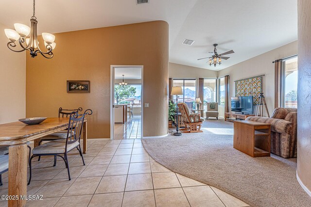 tiled dining area featuring ceiling fan with notable chandelier and lofted ceiling