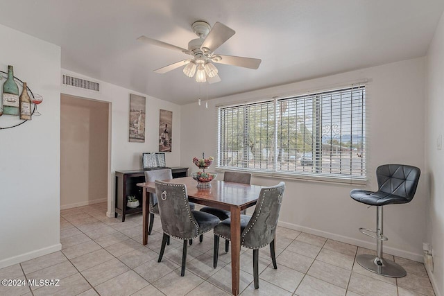 tiled dining space with ceiling fan