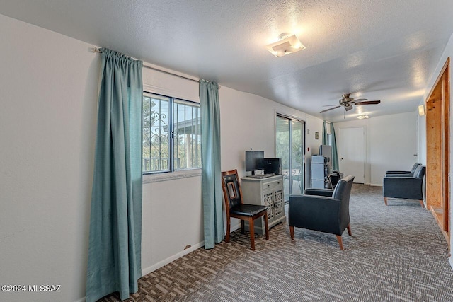 living area featuring a textured ceiling, carpet floors, and ceiling fan