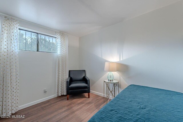 bedroom with dark wood-type flooring