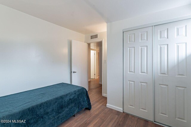 bedroom featuring dark hardwood / wood-style floors and a closet