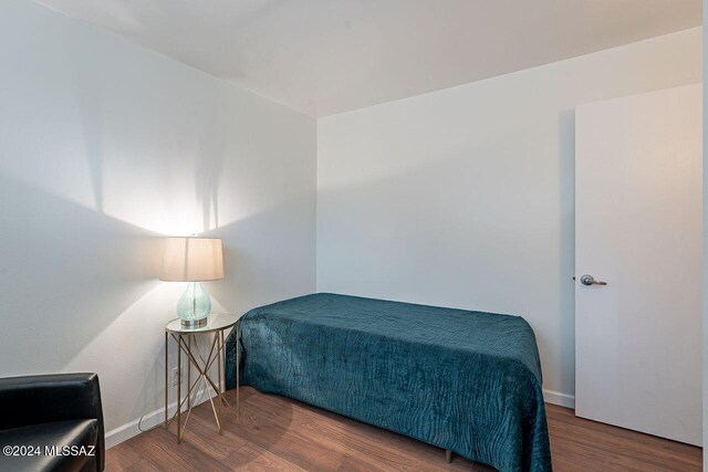 bedroom with dark wood-type flooring