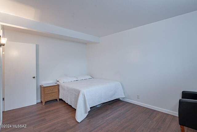 bedroom with dark wood-type flooring