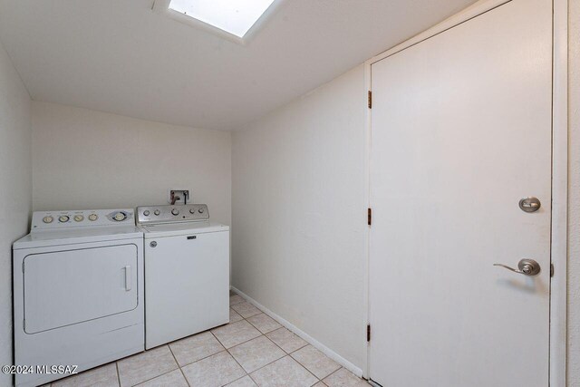 laundry room featuring light tile patterned floors and washing machine and clothes dryer