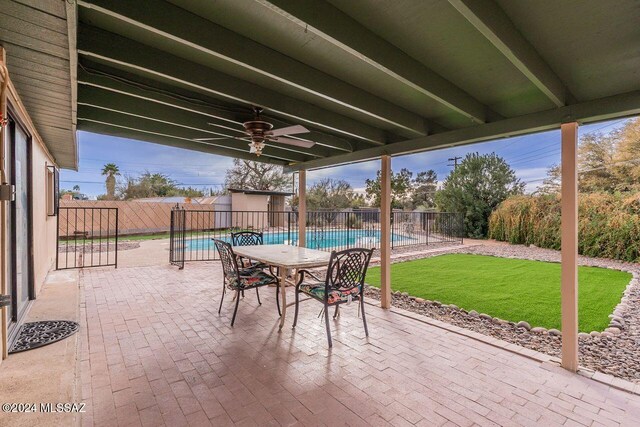 view of patio with a fenced in pool and ceiling fan