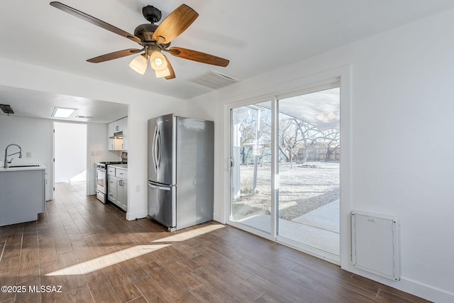 kitchen with white cabinetry, appliances with stainless steel finishes, dark hardwood / wood-style floors, and sink