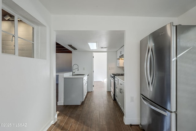 kitchen featuring dark hardwood / wood-style flooring, sink, stainless steel appliances, and white cabinets