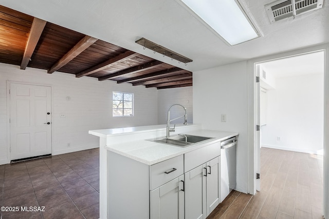 kitchen with white cabinetry, dishwasher, sink, kitchen peninsula, and beam ceiling