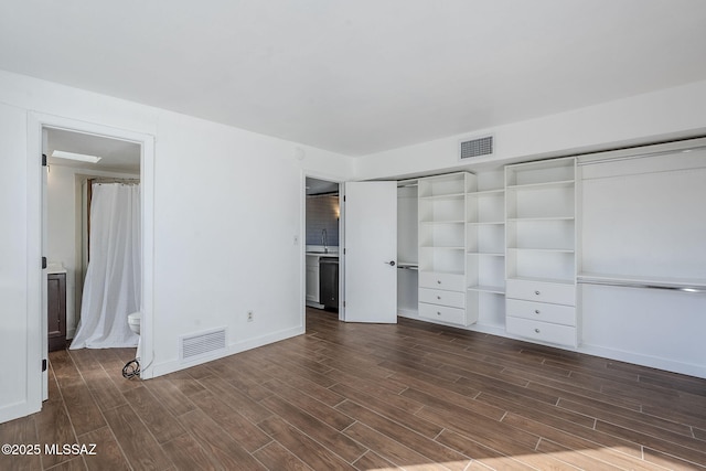 unfurnished bedroom featuring ensuite bathroom, sink, and dark wood-type flooring