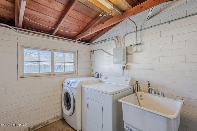 laundry area featuring electric panel, separate washer and dryer, and sink