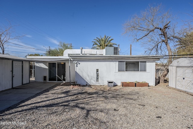 rear view of property featuring a storage shed