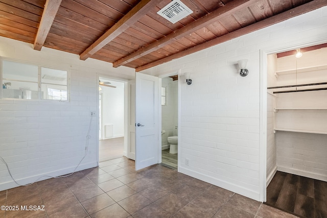 interior space with beamed ceiling, brick wall, and wooden ceiling