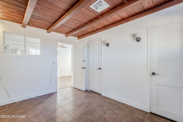 tiled spare room featuring beam ceiling, wood ceiling, and ceiling fan