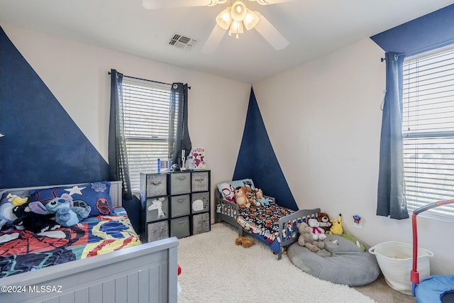 bedroom with carpet flooring, multiple windows, and ceiling fan