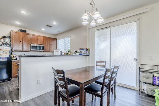 dining room with a notable chandelier and dark hardwood / wood-style flooring