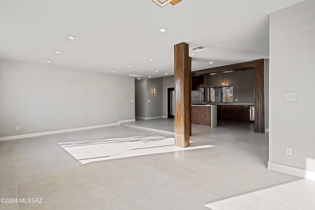 unfurnished room featuring ornate columns and light tile patterned flooring