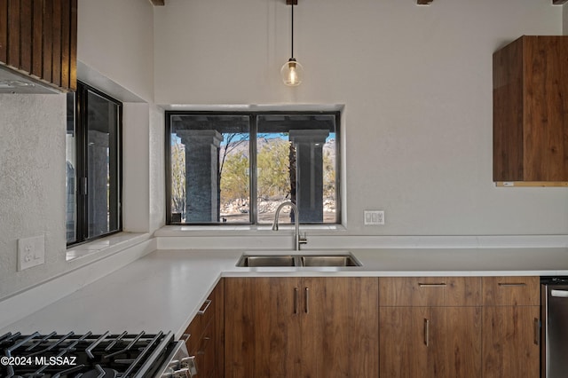 kitchen featuring sink, pendant lighting, and stove