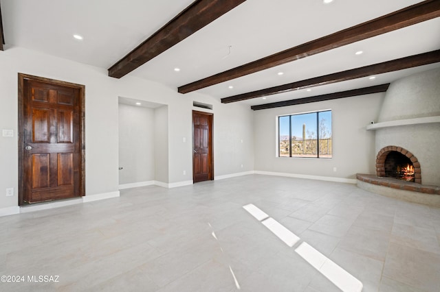 unfurnished living room with beamed ceiling and a brick fireplace