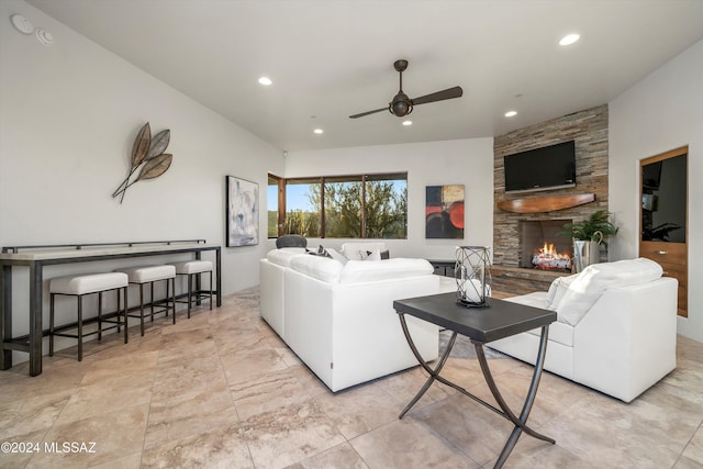 living room with ceiling fan and a stone fireplace