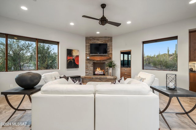 living room featuring ceiling fan and a fireplace