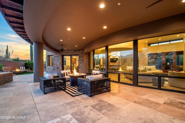 patio terrace at dusk with an outdoor living space with a fire pit