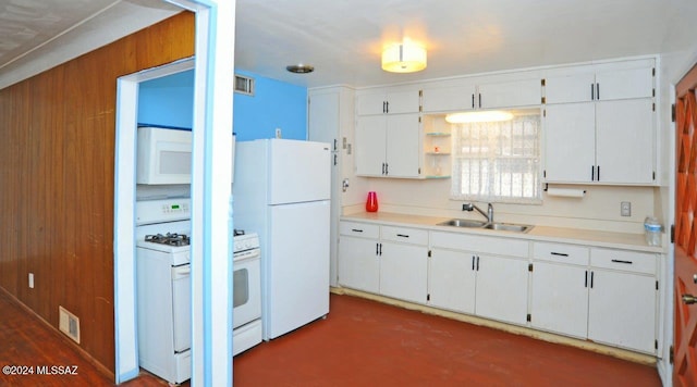 kitchen with white cabinets, white appliances, sink, and wooden walls