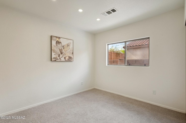 carpeted empty room featuring recessed lighting, visible vents, and baseboards