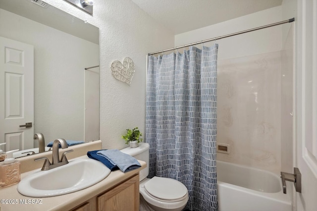 bathroom featuring a textured wall, vanity, toilet, and shower / bath combo with shower curtain