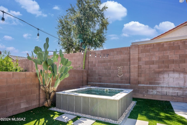 exterior space with a fenced backyard and a hot tub