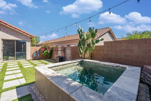 view of pool with an outdoor hot tub and fence