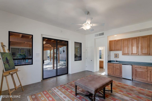 kitchen featuring ceiling fan, dishwasher, sink, and dark tile patterned floors