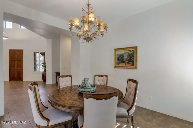 tiled dining room featuring an inviting chandelier