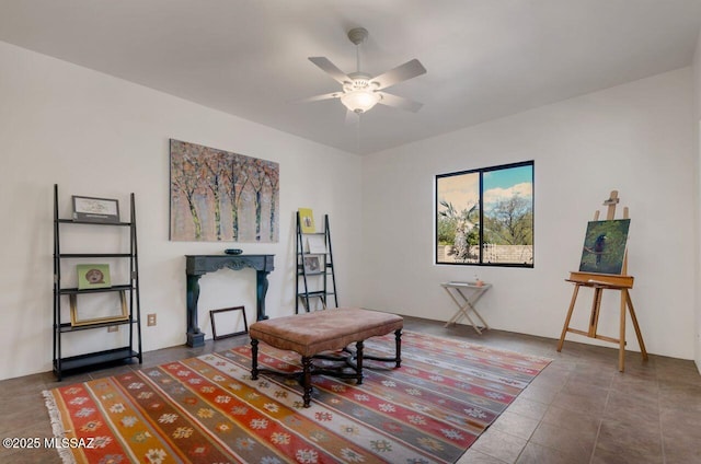 sitting room featuring dark tile patterned floors and ceiling fan