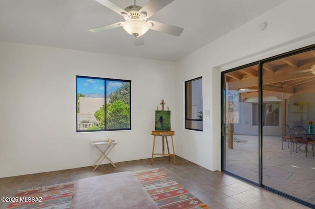 tiled spare room featuring ceiling fan