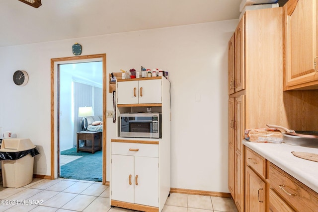 kitchen featuring light tile patterned floors and light brown cabinetry