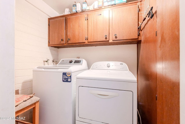 laundry room featuring washer and clothes dryer and cabinets