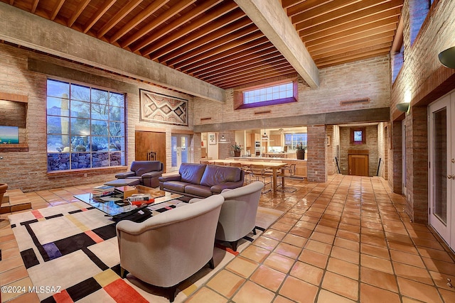 living room featuring beamed ceiling, light tile patterned flooring, and a high ceiling