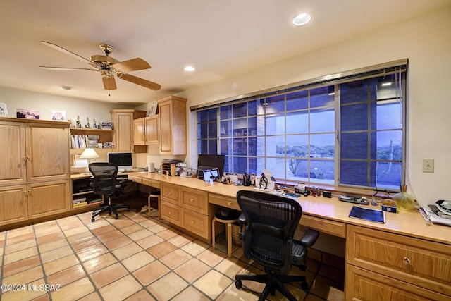 tiled office space with built in desk and ceiling fan