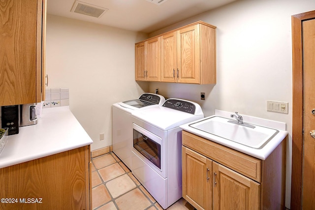 laundry room with light tile patterned flooring, cabinets, separate washer and dryer, and sink