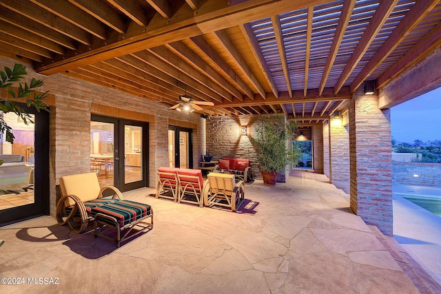 patio terrace at dusk featuring ceiling fan and an outdoor hangout area