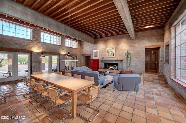 dining room with french doors, a towering ceiling, wood ceiling, and beamed ceiling